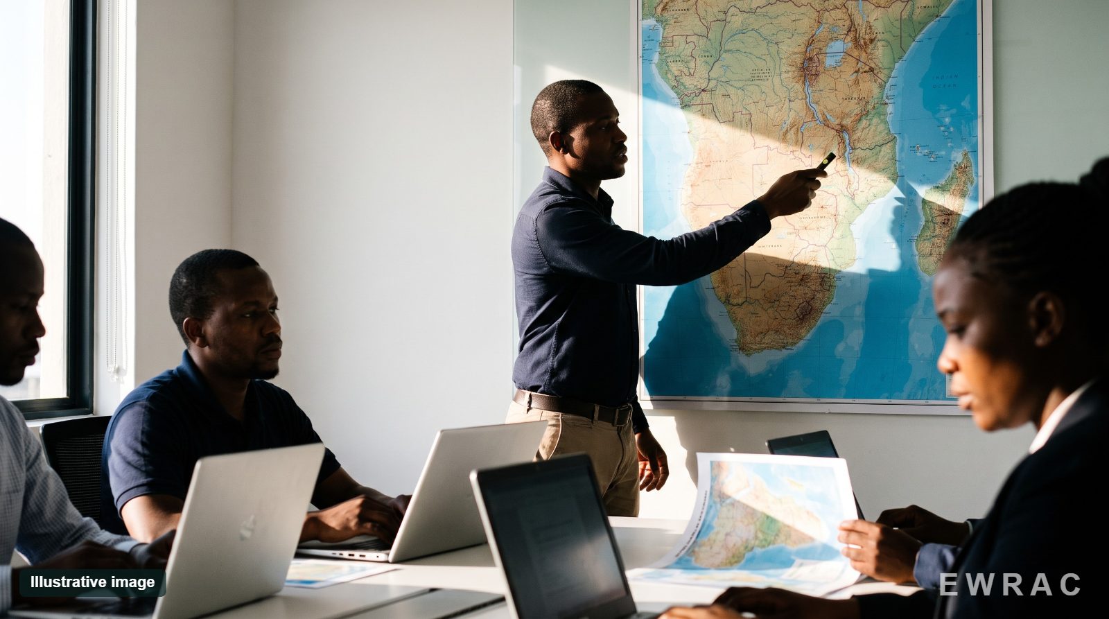 Illustrative image: analysts in a training session at a wall map of Southern and East Africa